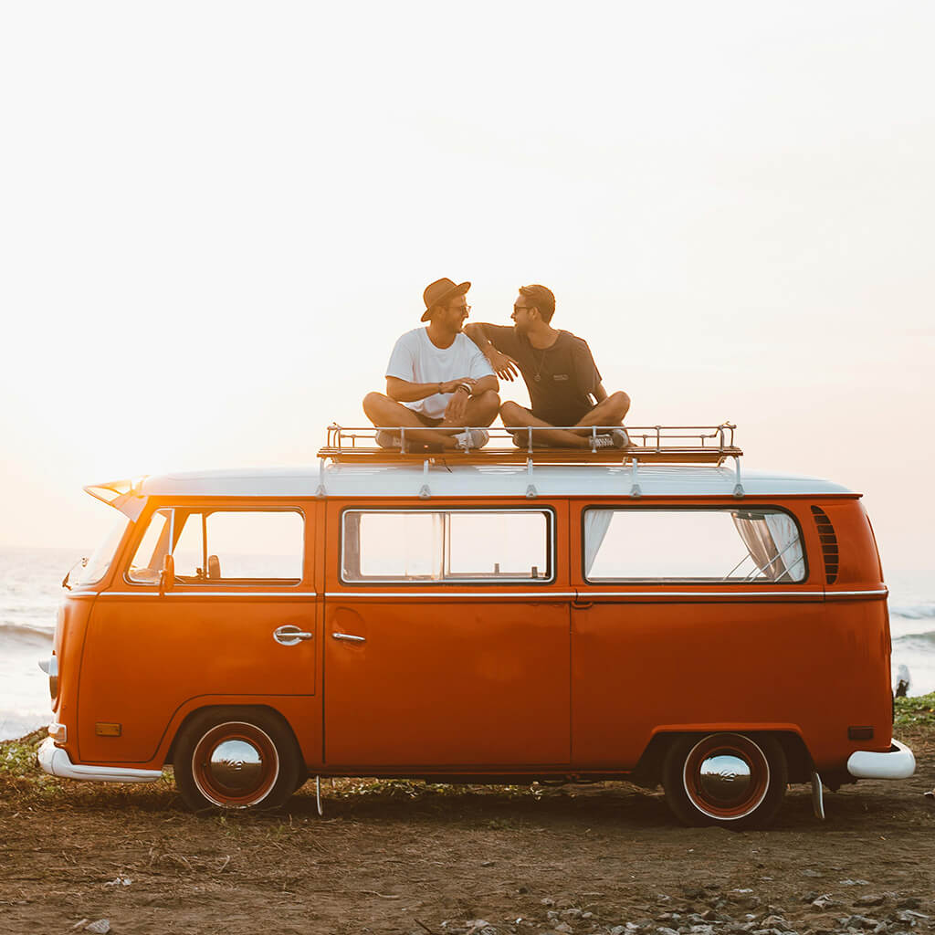 Vakantiegangers en reizigers vrienden op dak volkswagen camper